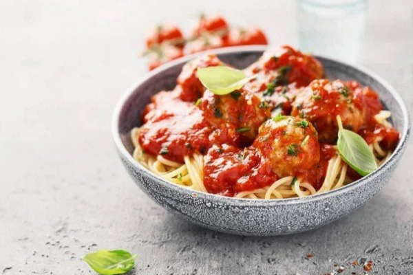 Spaghetti with Mediterranean chicken breast in a bowl.
